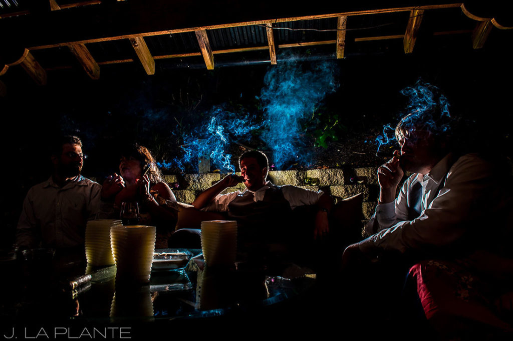 groom smoking cigars with groomsmen
