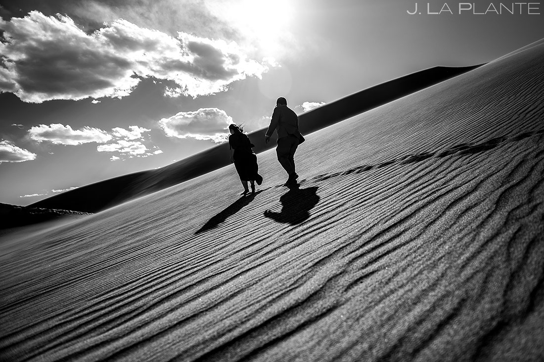 bride and groom hiking the sand dunes