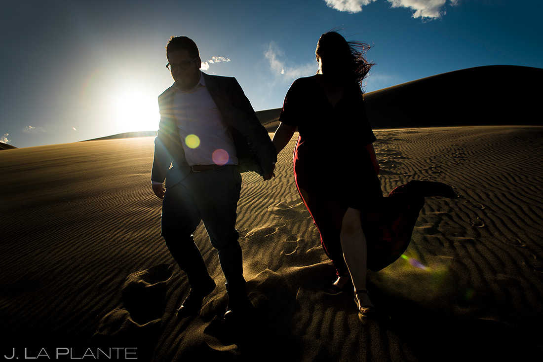 bride and groom hiking the great sand dunes at sunset