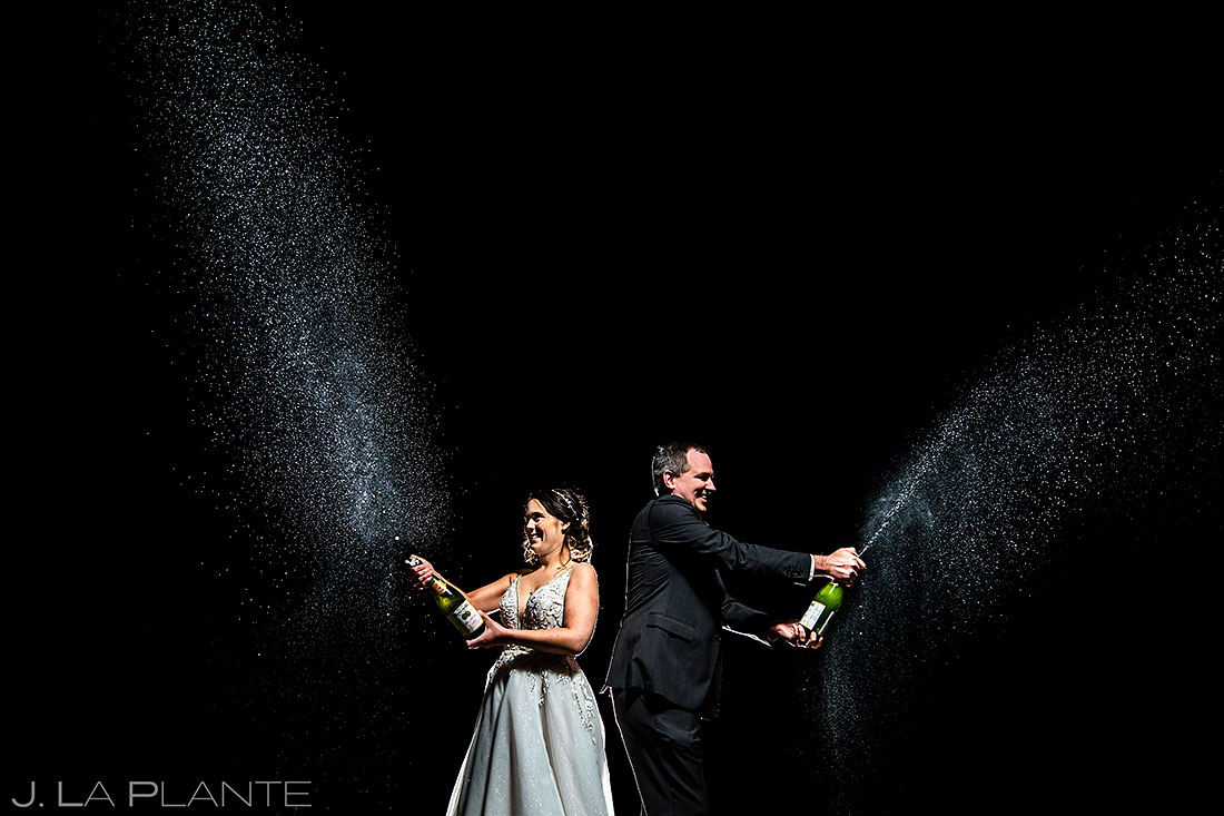 bride and groom spraying champagne in colorado