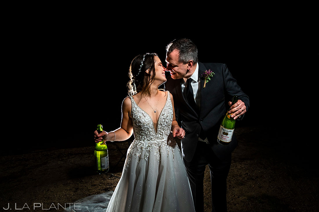 nighttime wedding photo bride and groom drinking champagne