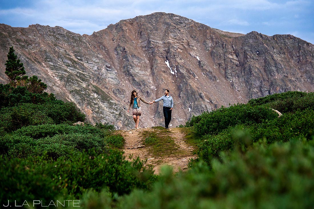 bride and groom to be hiking in the rocky mountains