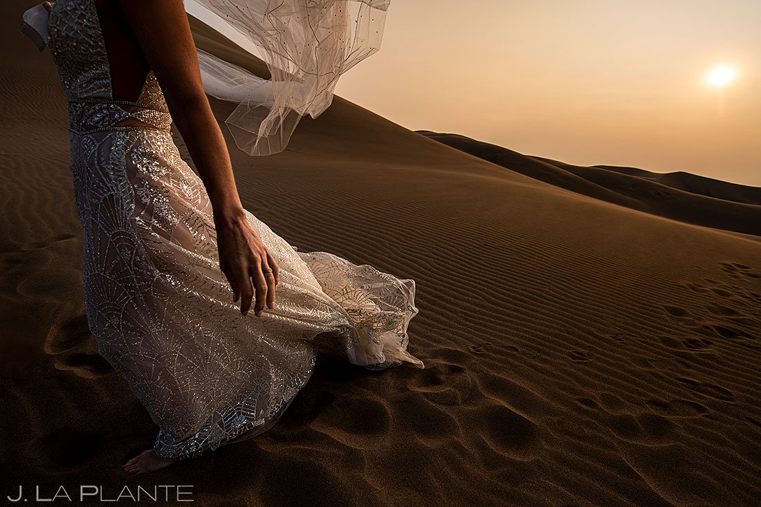 unique detail photo of bride's wedding dress and veil at sunset