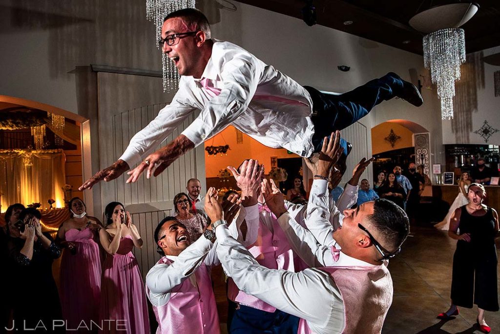 groom being thrown into the air by groomsmen at Bella Sera Event Center