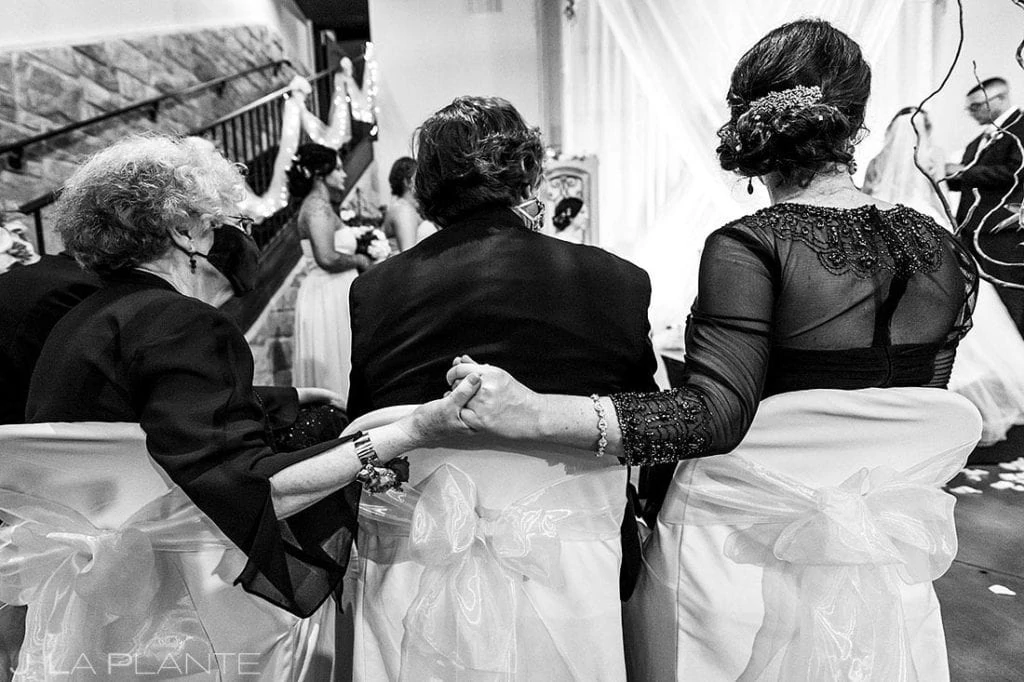 mother and grandmother of the bride holding hands during ceremony