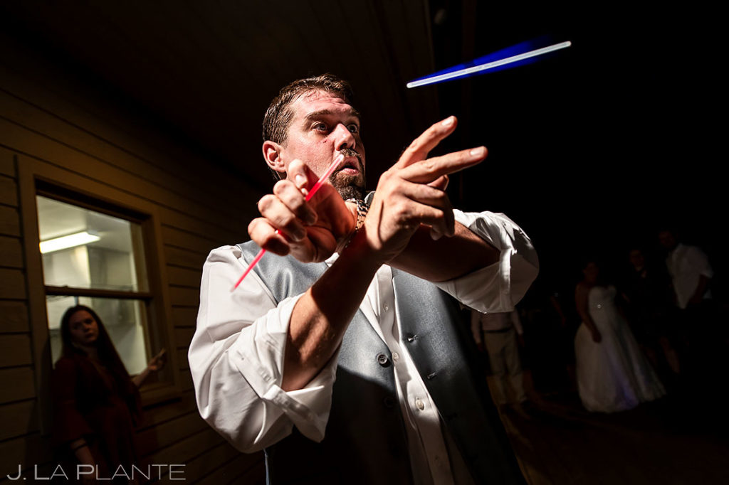 groom juggling glow sticks during wedding reception