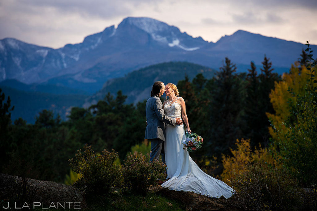 bride and groom kissing in front of Longs Peak