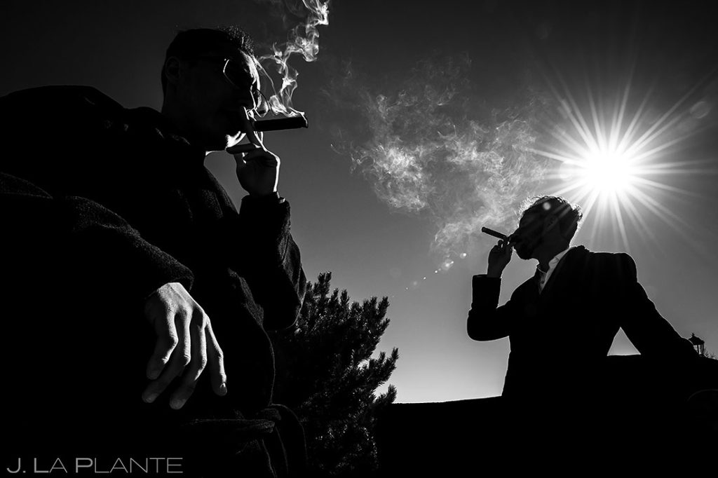 groom smoking cigars with best man