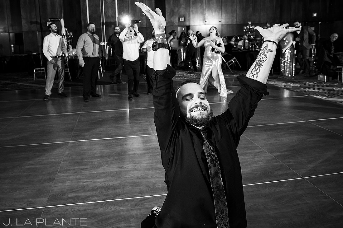 groom throwing the garter to his friends at wedding reception