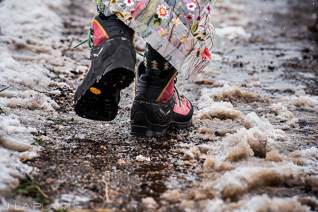 bride wearing hiking boots during muddy winter wedding