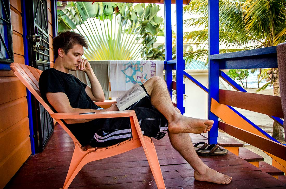 get to know your wedding photographers Jesse reading book in Belize