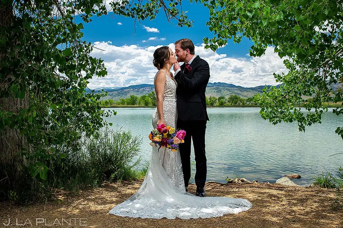 portrait of bride and groom standing next to lake in boulder