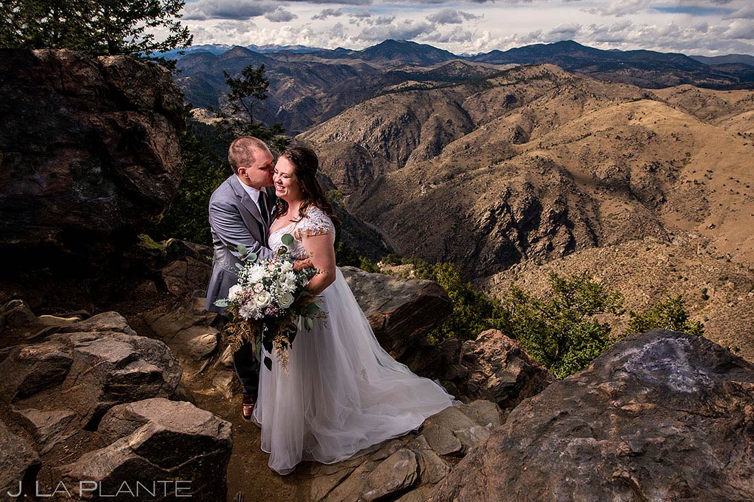 bride and groom kissing on mountain overlook