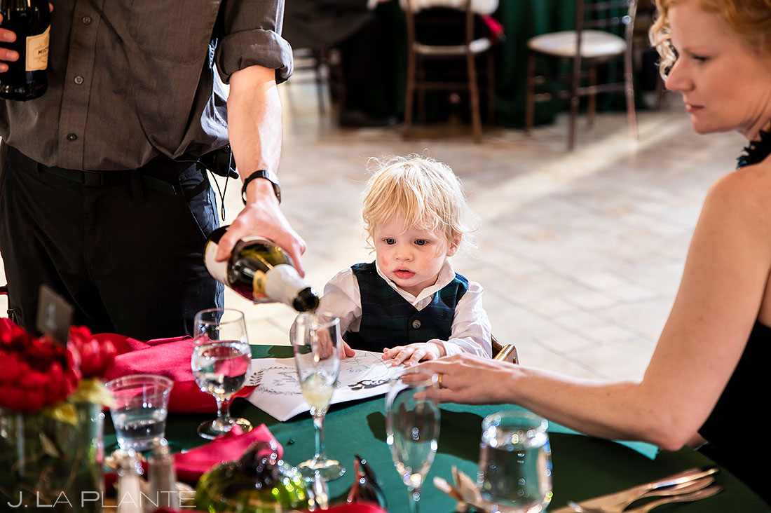 ring bearer watching wait staff pour champagne
