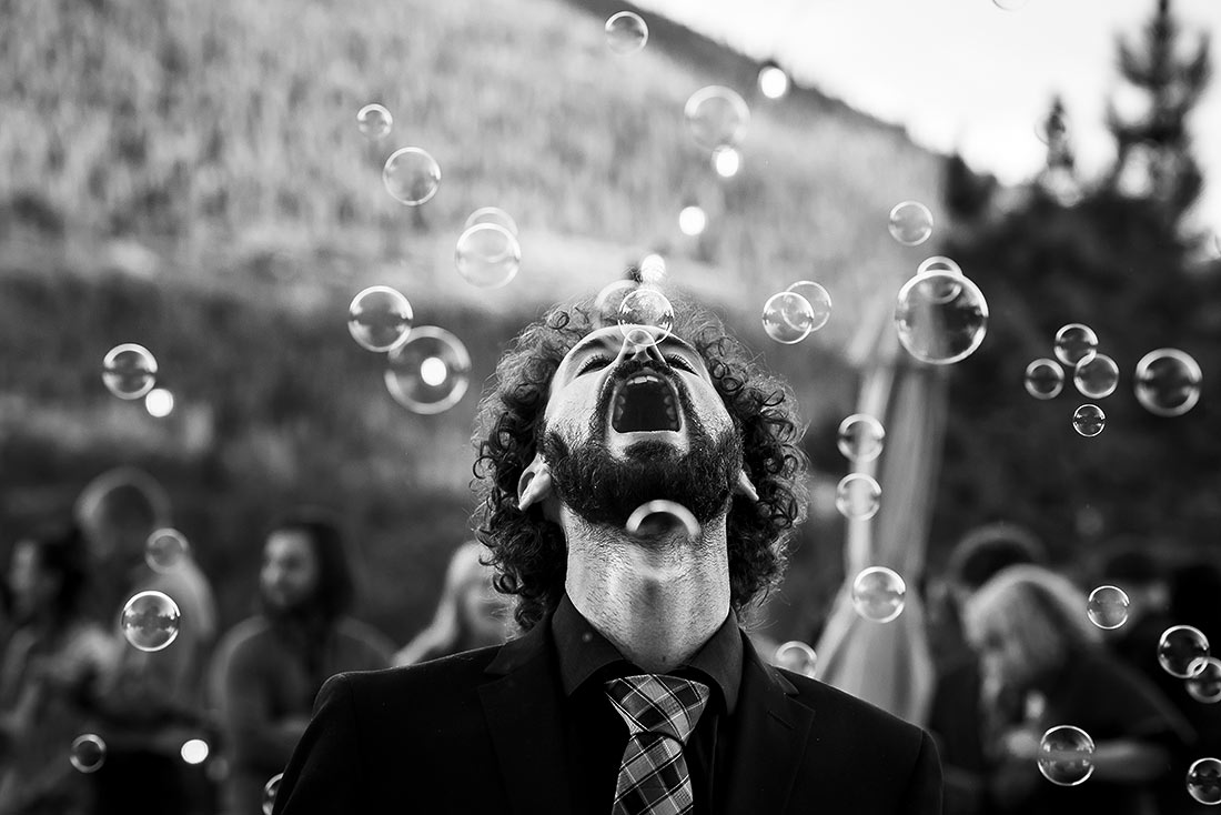 wedding guest trying to catch bubbles in his mouth