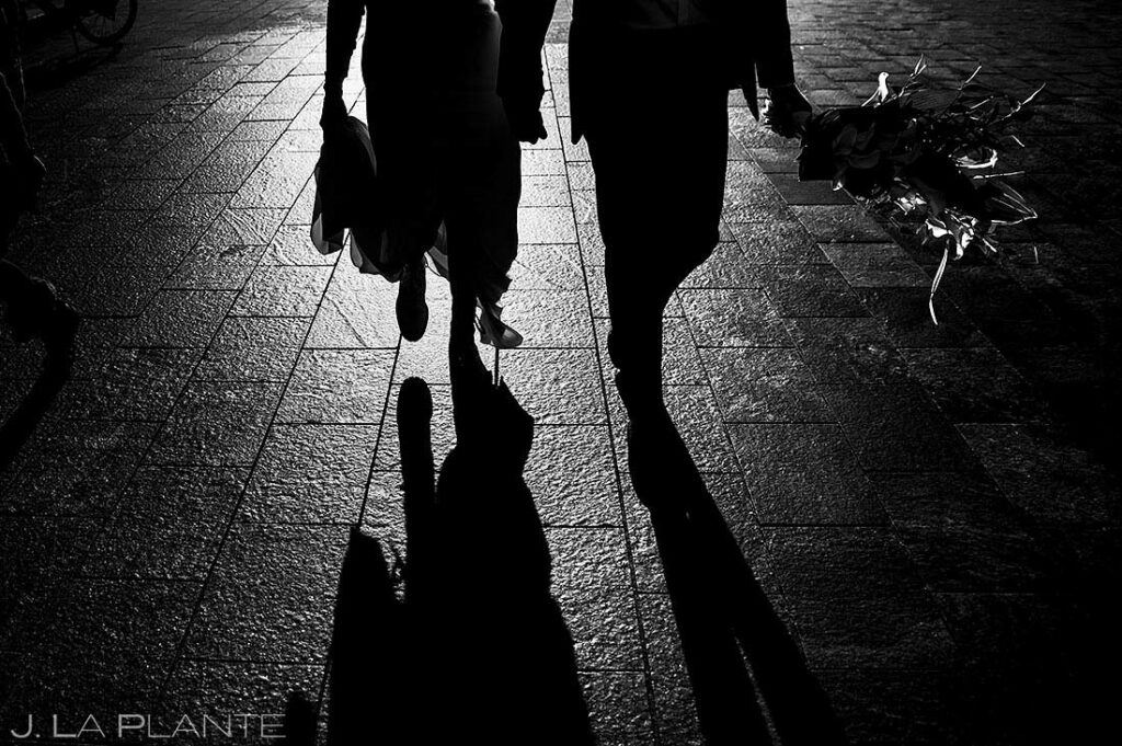 silhouettes of bride and groom walking down city street