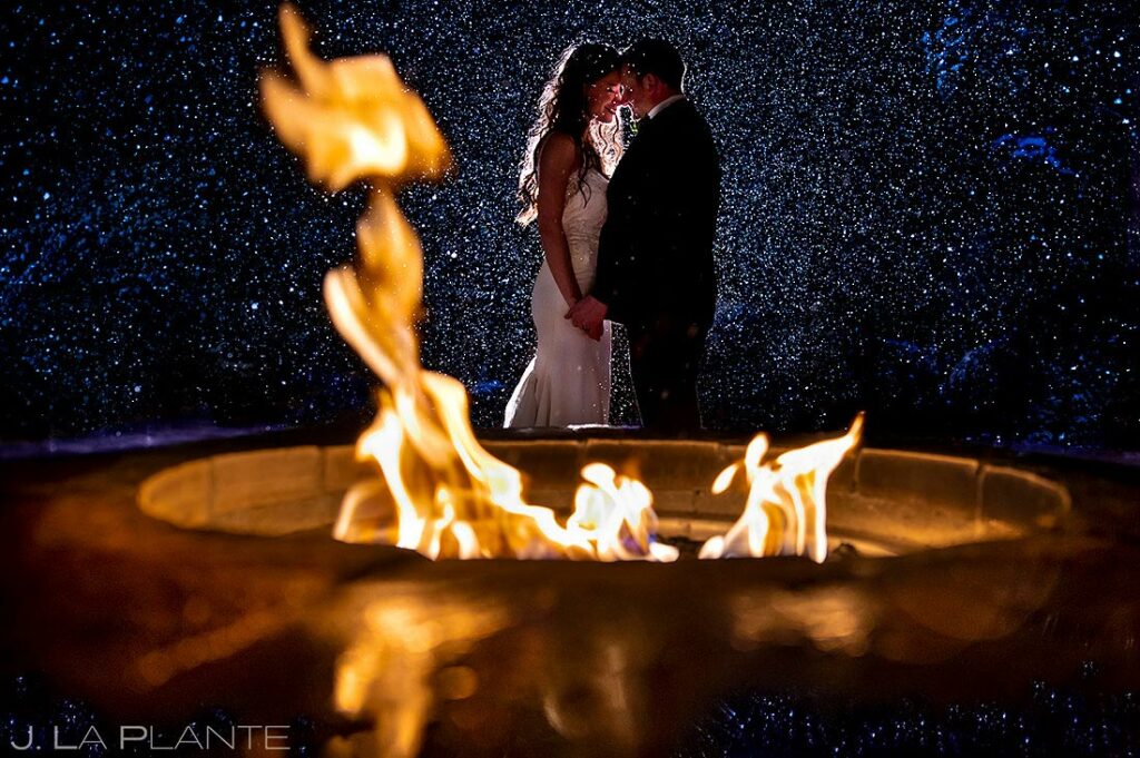 bride and groom by the fire outside wedding venue