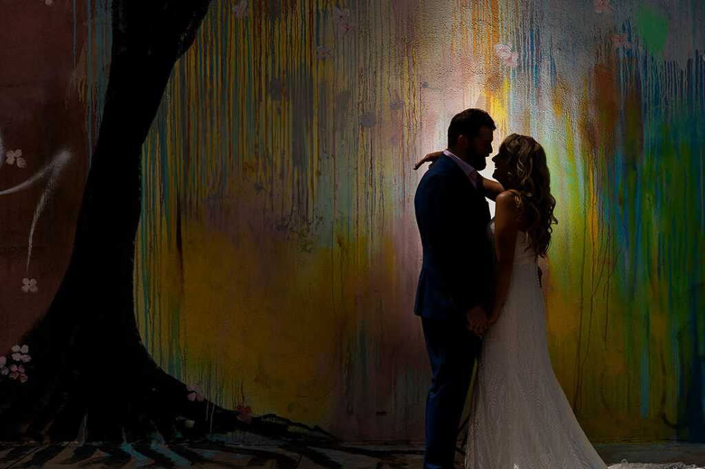 portrait of bride and groom with mural at Blanc Denver wedding