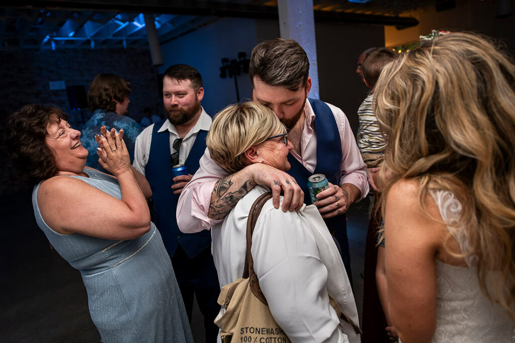 groom hugging mother during wedding reception