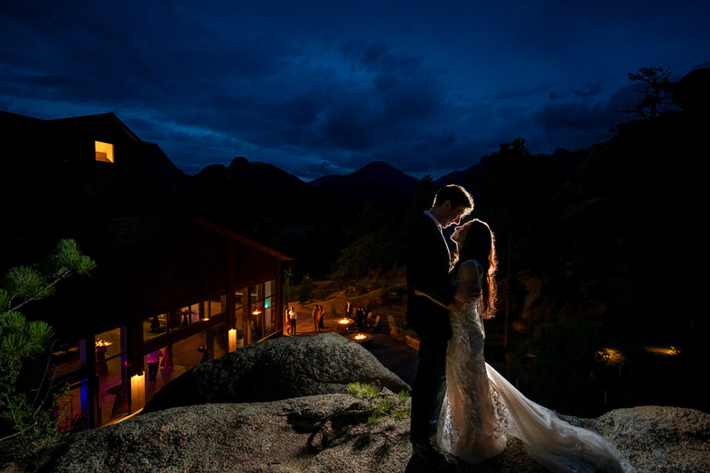 nighttime portrait of bride and groom outside wedding venue