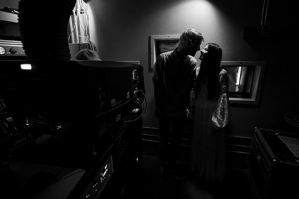 portrait of bride and groom in projection room at movie theater