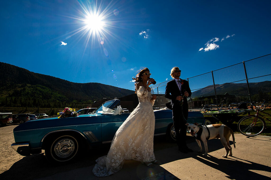 bride and groom with convertible getaway vehicle