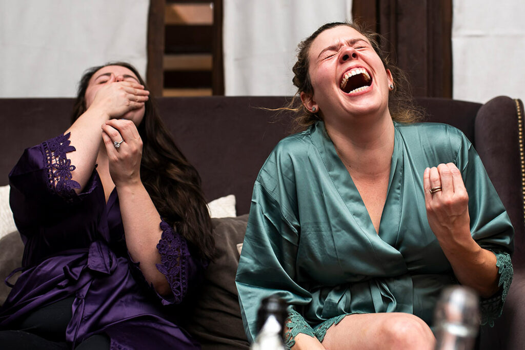 bridesmaids laughing with each other before wedding