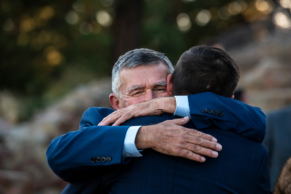 groom hugging father at Sunrise Amphitheater wedding