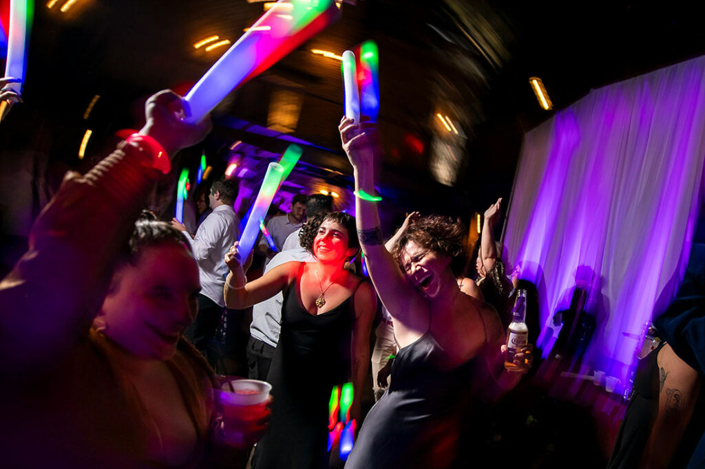 guests dancing with glow sticks during wedding reception