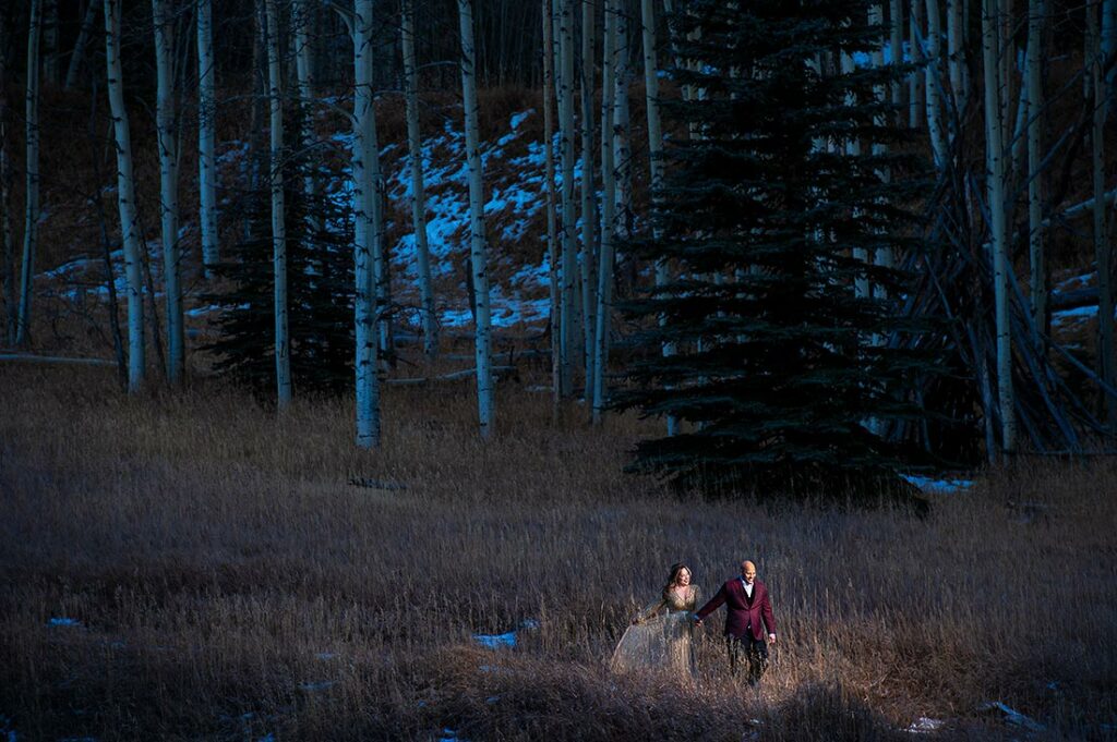bride and groom to be walking in the woods during Pueblo engagement session