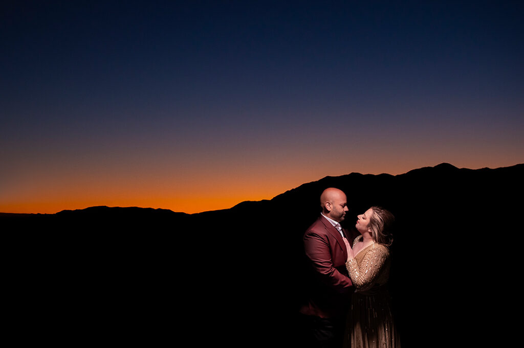 sunset portrait of bride and groom to be by the mountains