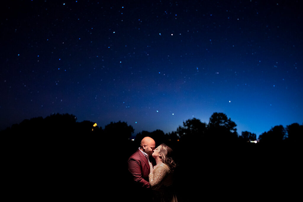 bride and groom kissing under the stars