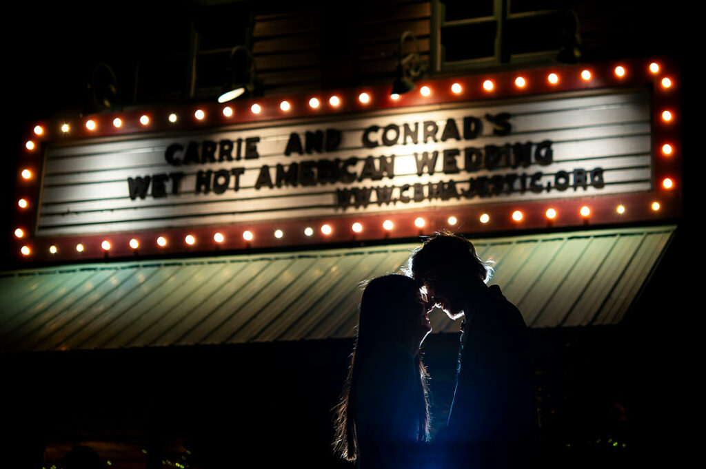 bride and groom portrait in front of movie theater marquee