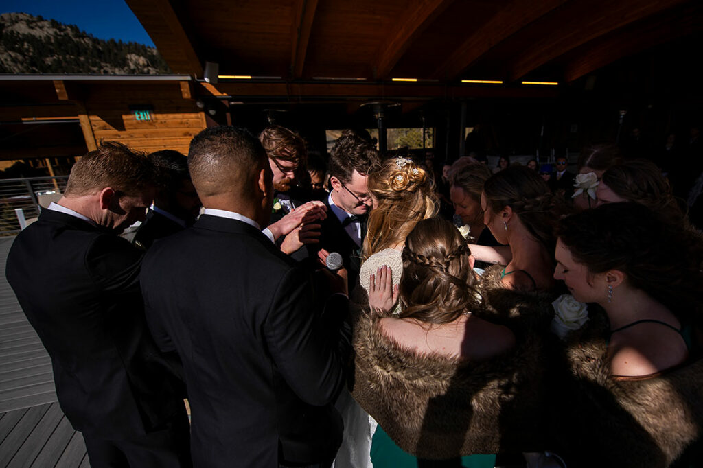 SkyView wedding at Fall River Village wedding party praying together during ceremony
