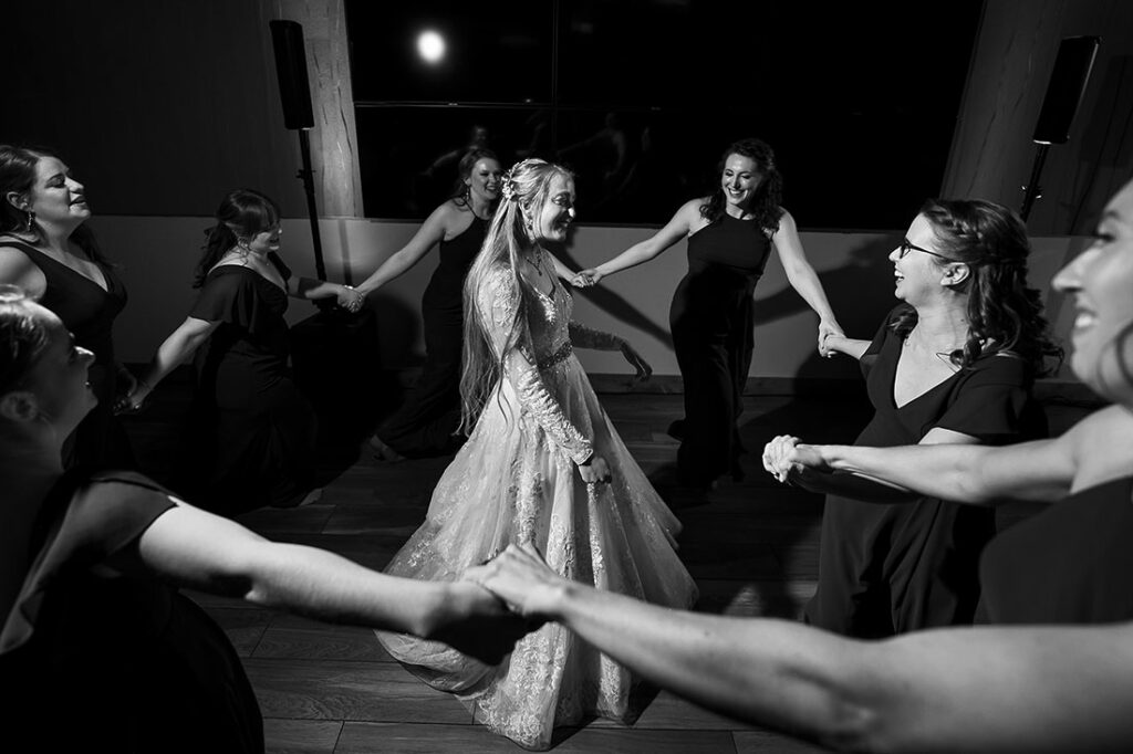 bride encircled by bridesmaids during dance party