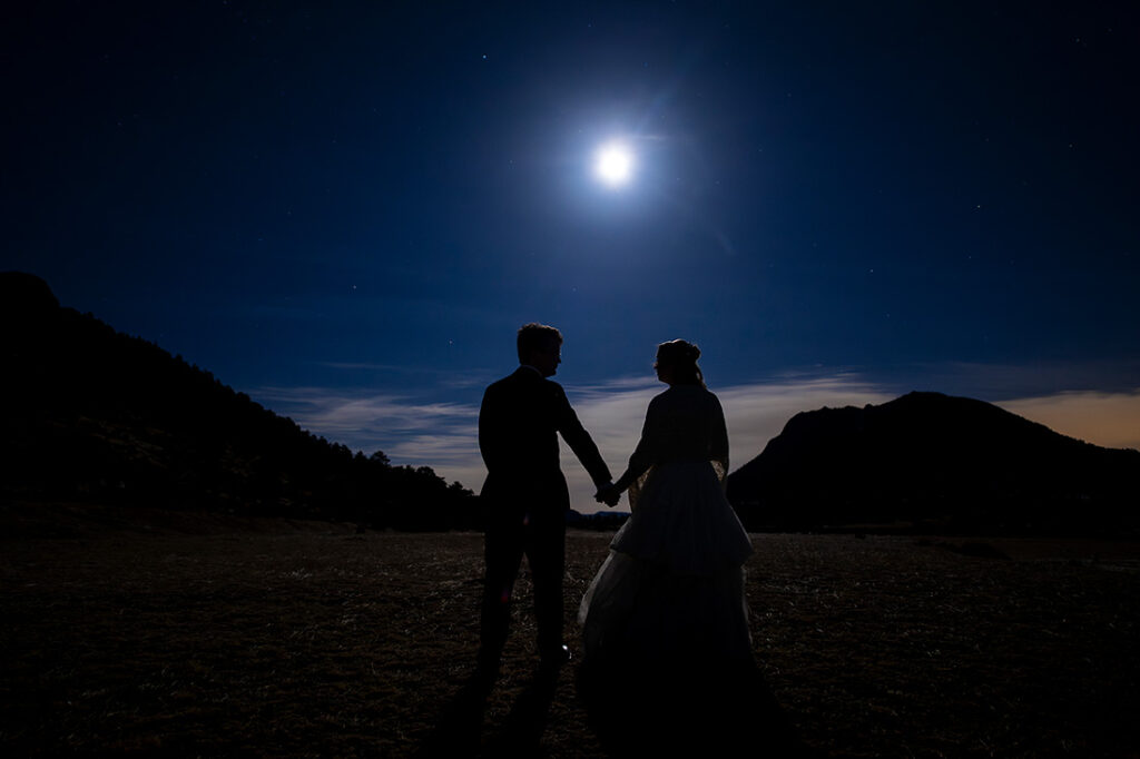 bride and groom illuminated by the moonlight in Rocky Mountain National Park