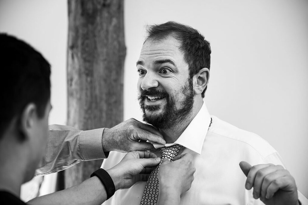 Taharaa Mountain Lodge wedding groom tying tie