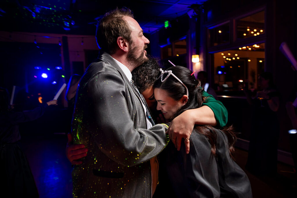 bride and groom hugging wedding guest at the end of the night