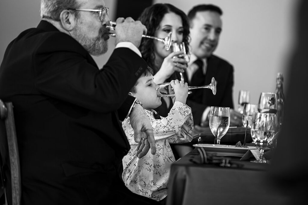 ringer bearer sneaking champagne during wedding reception
