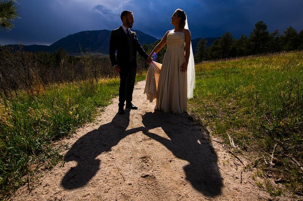 silhouette photo of bride and groom in front of mountains