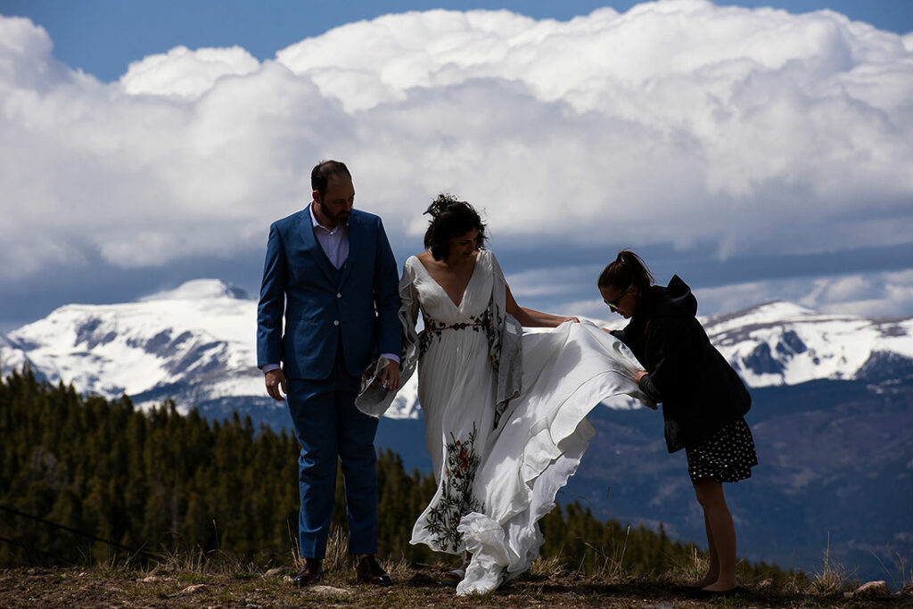wedding photographer fluffing bride's dress at Echo Mountain wedding in Colorado
