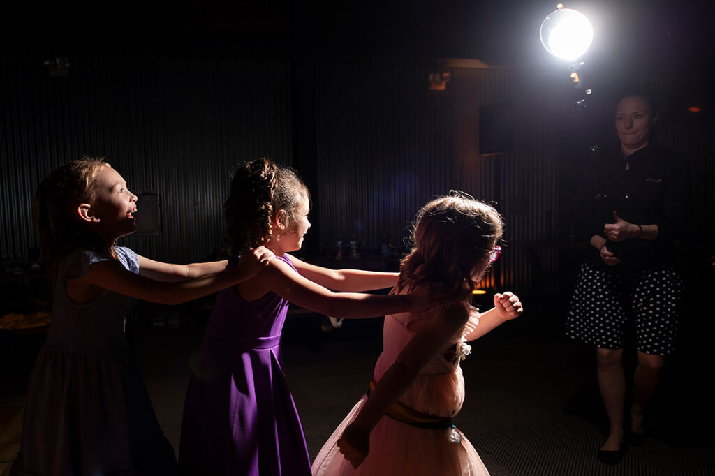 wedding photographer lighting kids dancing during reception