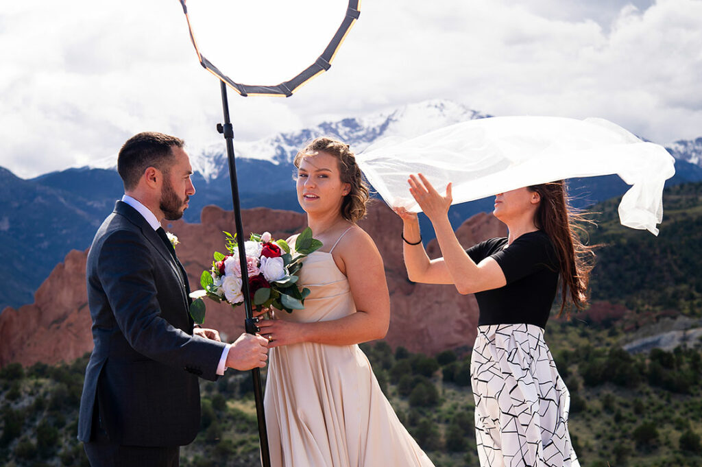 wedding photographer fixing bride's veil at Pinecrest Wedding in Colorado Springs